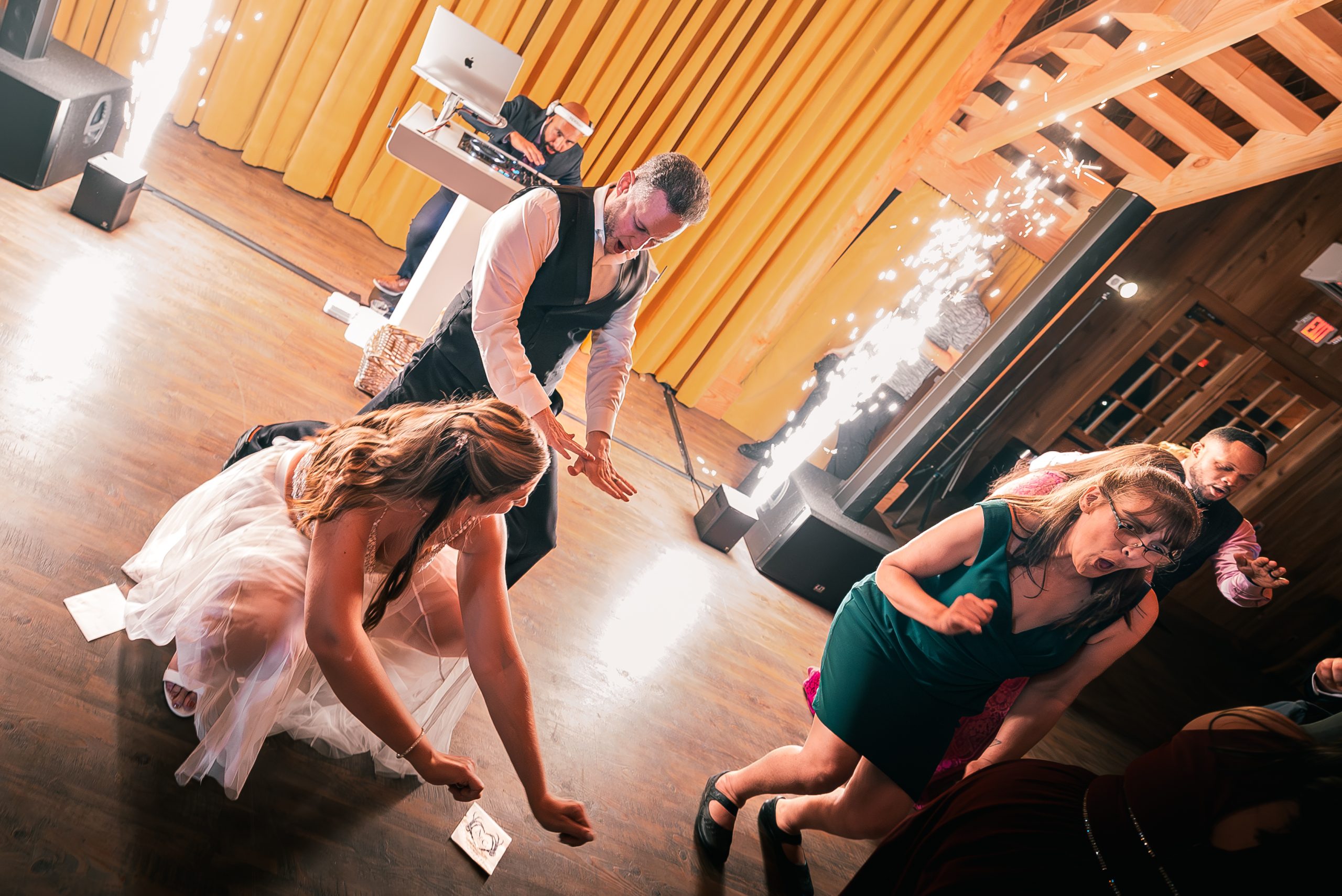High energy wedding dance floor with DJ and guests celebrating